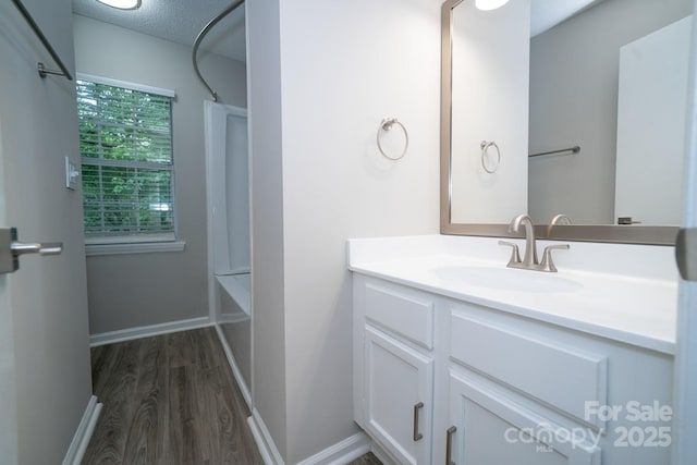 8125 Sheringham Way, Charlotte, NC 28227 - full bathroom with vanity, wood finished floors, shower / bathtub combination, baseboards, and a textured ceiling