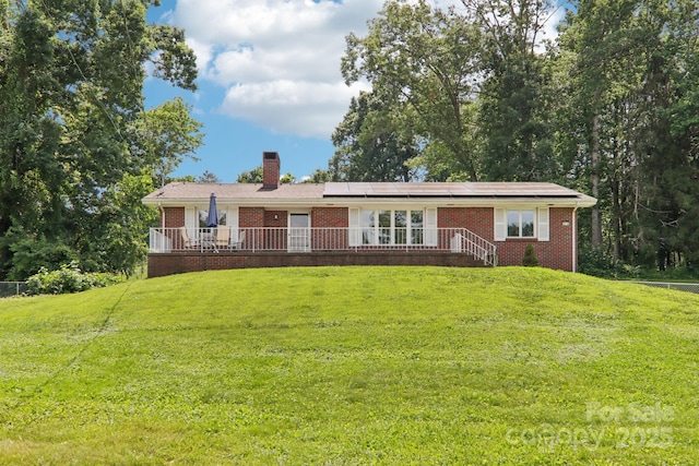 318 Old Leicester Hwy, Asheville, NC 28806 - single story home with brick siding, roof mounted solar panels, a front yard, and a chimney