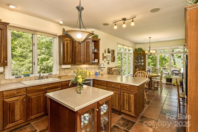 25 Windsong Dr, Fairview, NC 28730 - kitchen with a sink, a peninsula, decorative backsplash, light countertops, and a chandelier