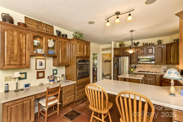 25 Windsong Dr, Fairview, NC 28730 - kitchen with appliances with stainless steel finishes, light countertops, decorative backsplash, a breakfast bar, and glass insert cabinets