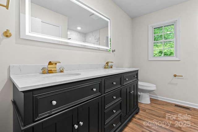 520 Hickory Ave, Hudson, NC 28638 - bathroom featuring double vanity, toilet, baseboards, and wood finished floors