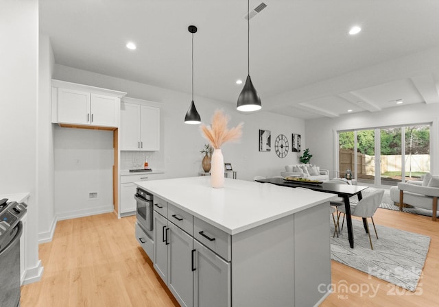 5615 Lantana Ave Unit B, Charlotte, NC 28205 - kitchen with white cabinets, open floor plan, light wood-style floors, a kitchen island, and light countertops