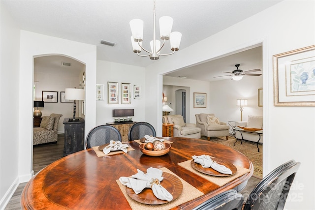 1041 Brawley School Rd, Mooresville, NC 28117 - dining room with arched walkways, a chandelier, wood finished floors, a ceiling fan, and baseboards