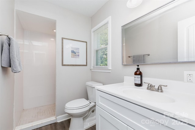 1041 Brawley School Rd, Mooresville, NC 28117 - bathroom featuring a tile shower, toilet, vanity, and wood finished floors