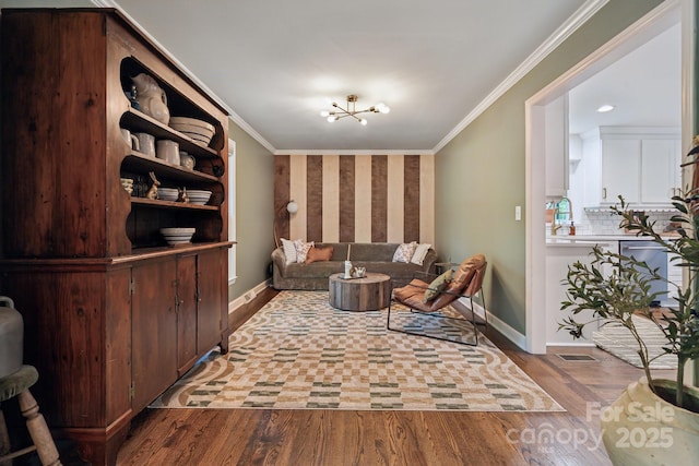 2507 Connemara Dr, Matthews, NC 28105 - living area featuring a chandelier, baseboards, wood finished floors, and ornamental molding
