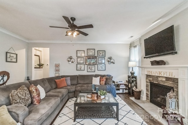 2112 Balting Glass Dr, Indian Trail, NC 28079 - living area featuring ceiling fan, ornamental molding, a fireplace with raised hearth, and wood finished floors