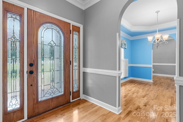 5362 Beacon Ridge Dr, Granite Falls, NC 28630 - entrance foyer featuring arched walkways, crown molding, a chandelier, baseboards, and wood finished floors