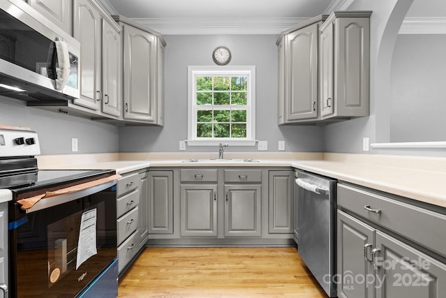 5362 Beacon Ridge Dr, Granite Falls, NC 28630 - kitchen with gray cabinetry, stainless steel appliances, a sink, crown molding, and arched walkways