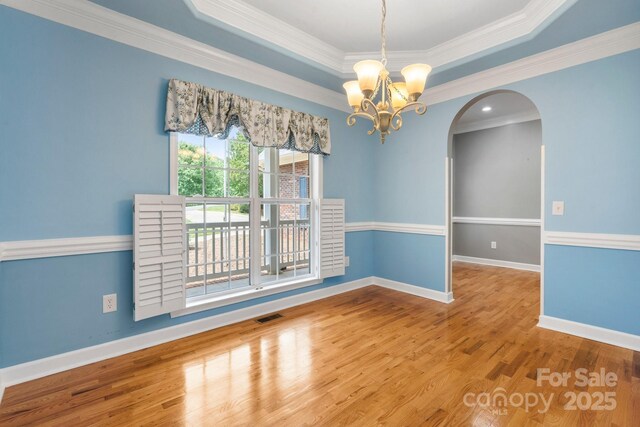 5362 Beacon Ridge Dr, Granite Falls, NC 28630 - empty room with arched walkways, a chandelier, ornamental molding, wood finished floors, and a tray ceiling