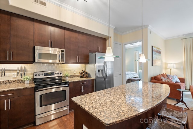 4620 Piedmont Row Dr Unit 308, Charlotte, NC 28210 - kitchen with stainless steel appliances, wood finished floors, a kitchen island, a breakfast bar, and ornamental molding