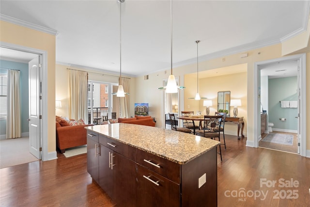 4620 Piedmont Row Dr Unit 308, Charlotte, NC 28210 - kitchen featuring open floor plan, ornamental molding, dark wood-type flooring, dark brown cabinets, and a center island