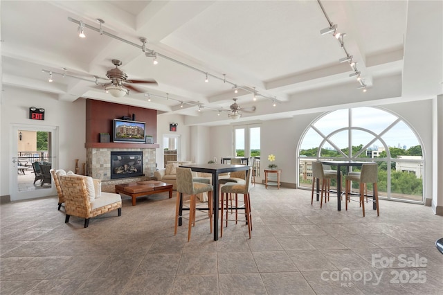 4620 Piedmont Row Dr Unit 308, Charlotte, NC 28210 - dining room with rail lighting, baseboards, a fireplace, a ceiling fan, and beamed ceiling