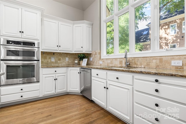 9219 Whispering Wind Dr, Charlotte, NC 28277 - kitchen with stainless steel appliances, a sink, white cabinetry, and tasteful backsplash