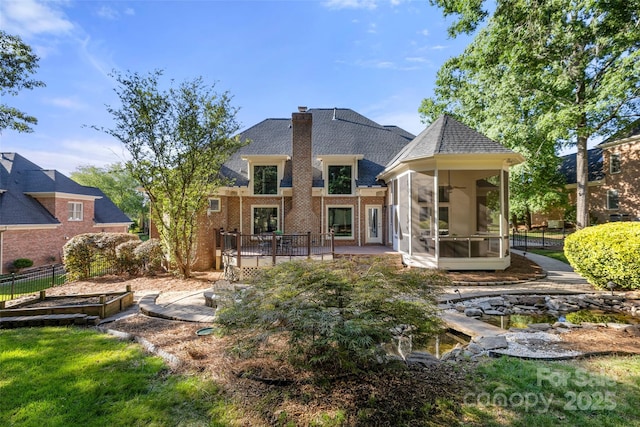 9219 Whispering Wind Dr, Charlotte, NC 28277 - back of property featuring a sunroom, brick siding, a shingled roof, a chimney, and a patio