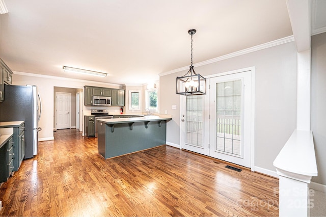 2728 Touchstone Cir, Newton, NC 28658 - kitchen featuring appliances with stainless steel finishes, a peninsula, a chandelier, wood finished floors, and ornamental molding