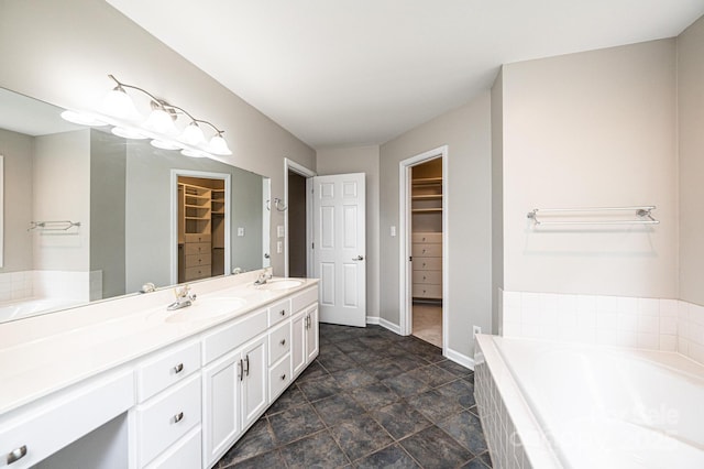 2728 Touchstone Cir, Newton, NC 28658 - bathroom featuring a garden tub, baseboards, double vanity, and a walk in closet