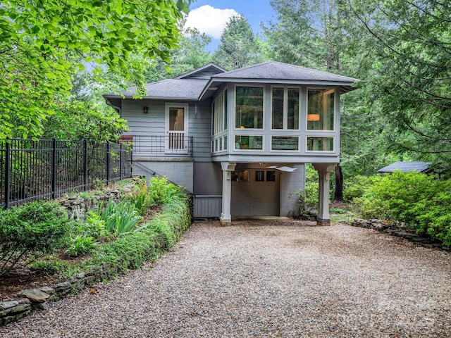 185 Greenstoke Loop, Tryon, NC 28782 - view of front of home with gravel driveway, a garage, a sunroom, and roof with shingles