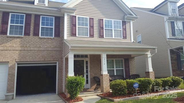 214 Minitree Ln, Charlotte, NC 28214 - view of front of home with covered porch, an attached garage, brick siding, and concrete driveway