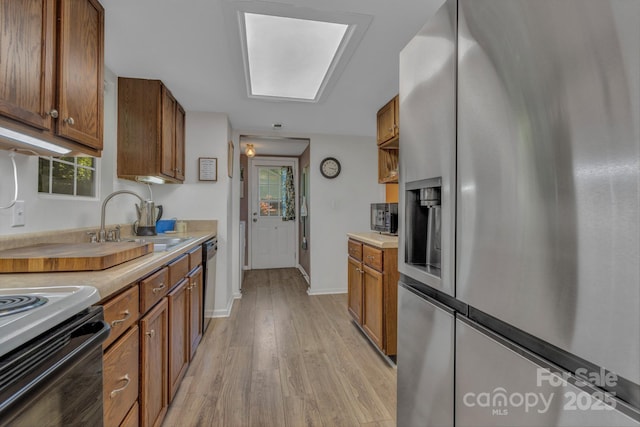 619 Beaverdam Rd, Asheville, NC 28804 - kitchen featuring stainless steel refrigerator with ice dispenser, brown cabinets, dishwashing machine, a sink, and light wood-style flooring