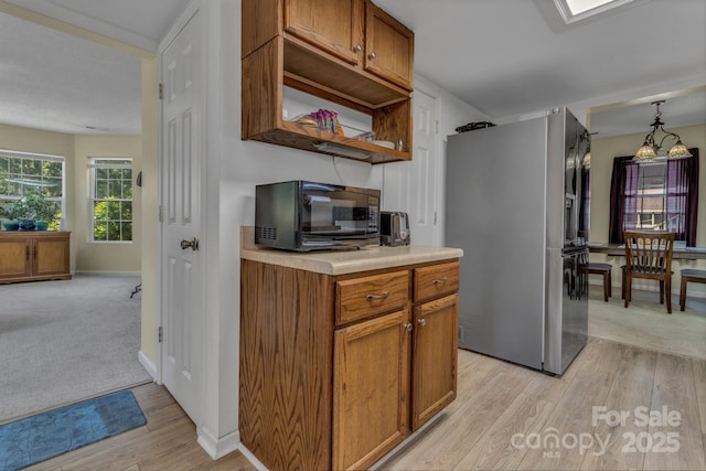 619 Beaverdam Rd, Asheville, NC 28804 - kitchen featuring freestanding refrigerator, light countertops, light wood-style floors, and brown cabinets