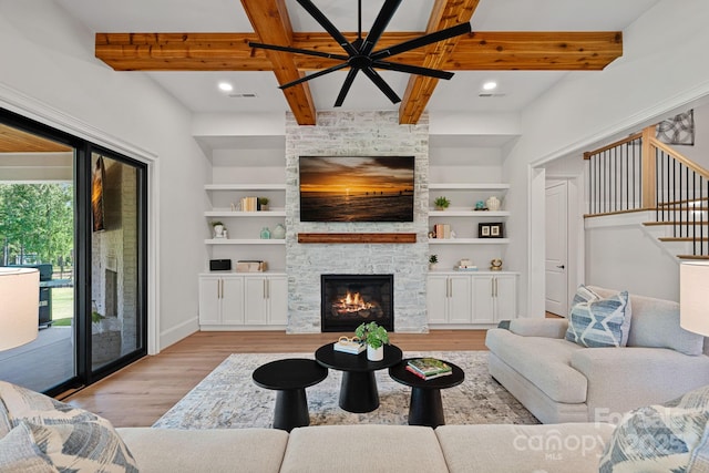 1405 Waxhaw Marvin Rd, Waxhaw, NC 28173 - living room featuring light wood-type flooring, a stone fireplace, baseboards, beam ceiling, and stairway