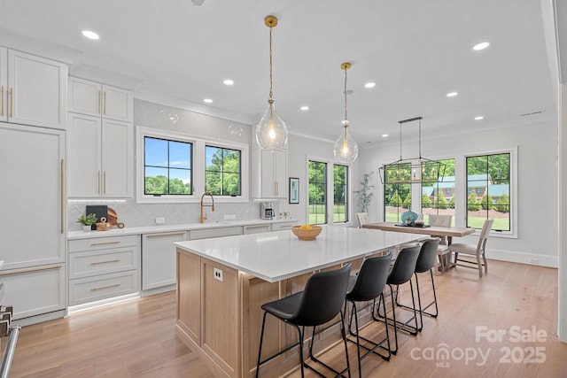 1405 Waxhaw Marvin Rd, Waxhaw, NC 28173 - kitchen featuring a center island, light wood-style floors, light countertops, backsplash, and recessed lighting
