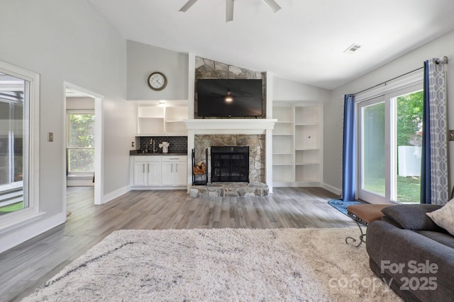 3807 Sweetgrass Ln, Charlotte, NC 28226 - living area with wood finished floors, a fireplace, ceiling fan, baseboards, and high vaulted ceiling