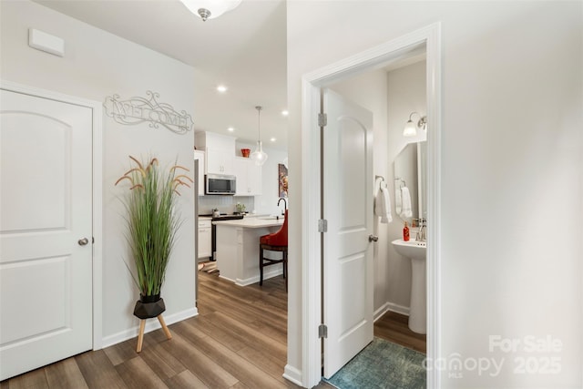 13327 Savaine St, Charlotte, NC 28278 - hallway featuring wood finished floors, a sink, recessed lighting, and baseboards