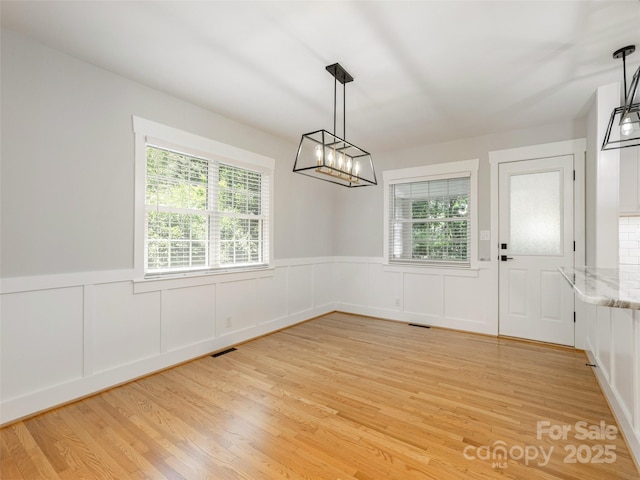 330 Balsam Rd, Hendersonville, NC 28792 - unfurnished dining area with light wood-style floors, a wainscoted wall, a chandelier, and a decorative wall