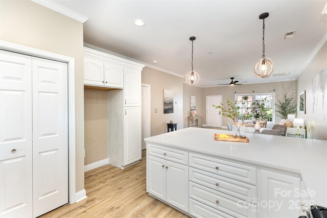 121 Quality Dr, Mount Holly, NC 28120 - kitchen featuring a ceiling fan, decorative light fixtures, ornamental molding, white cabinetry, and baseboards