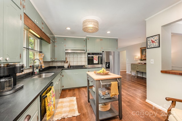 418 Melody Ln, Shelby, NC 28152 - kitchen with black appliances, a sink, green cabinetry, decorative backsplash, and wood finished floors