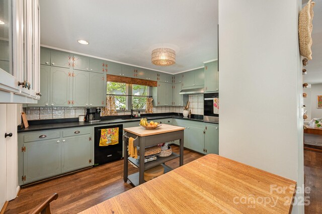 418 Melody Ln, Shelby, NC 28152 - kitchen with green cabinetry, black appliances, tasteful backsplash, dark countertops, and dark wood-style flooring