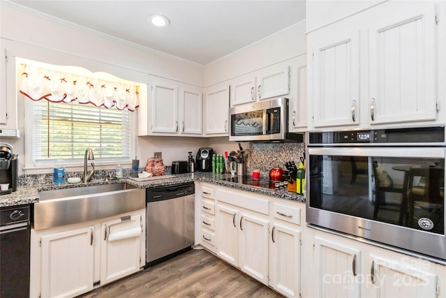 1104 Colony Ct, Gastonia, NC 28056 - kitchen featuring appliances with stainless steel finishes, a sink, crown molding, wood finished floors, and white cabinetry