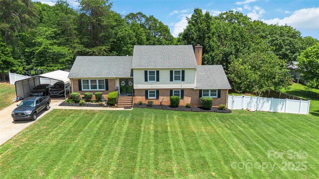 1104 Colony Ct, Gastonia, NC 28056 - tri-level home featuring brick siding, a detached carport, concrete driveway, a chimney, and roof with shingles