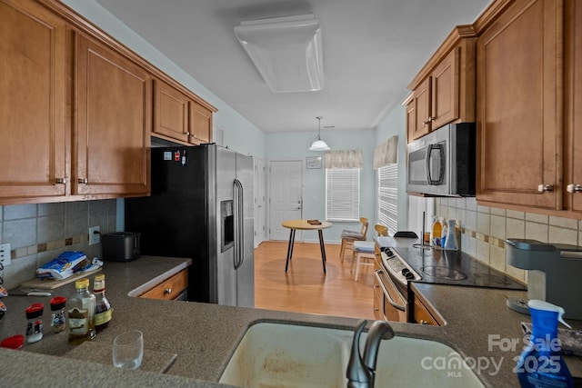 19157 Mallard Dr, Fort Mill, SC 29707 - kitchen with appliances with stainless steel finishes, brown cabinets, dark countertops, and backsplash