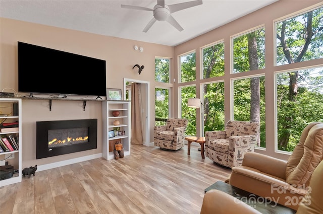 145 Old Still Rd, Maggie Valley, NC 28751 - living room with ceiling fan, a glass covered fireplace, and wood finished floors