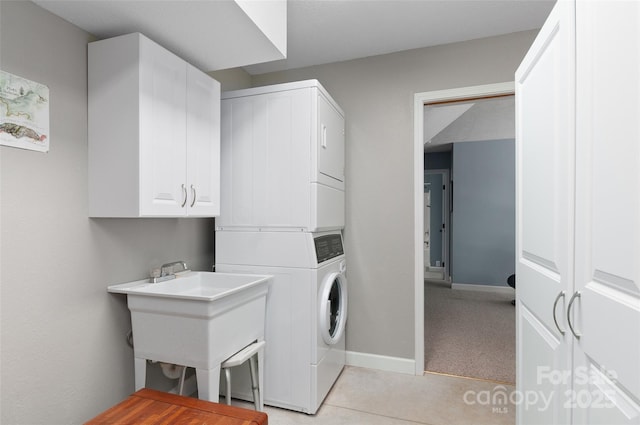 145 Old Still Rd, Maggie Valley, NC 28751 - laundry area featuring stacked washer and clothes dryer, cabinet space, baseboards, and light tile patterned floors
