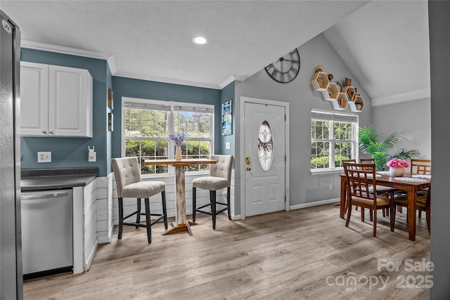 7830 Sarah Dr, Denver, NC 28037 - dining room featuring ornamental molding, light wood-style floors, a textured ceiling, lofted ceiling, and baseboards