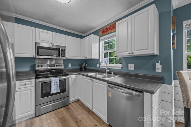 7830 Sarah Dr, Denver, NC 28037 - kitchen with appliances with stainless steel finishes, a sink, dark countertops, white cabinets, and a textured ceiling