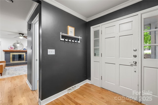 5016 Celeste Ct, Charlotte, NC 28270 - entryway featuring light wood finished floors, a ceiling fan, ornamental molding, baseboards, and a brick fireplace