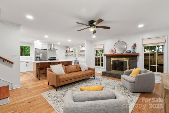 5016 Celeste Ct, Charlotte, NC 28270 - living room with plenty of natural light, a ceiling fan, a brick fireplace, recessed lighting, and light wood-style flooring