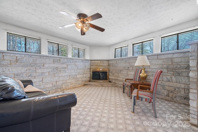 2866 Old Morganton Rd, Lenoir, NC 28645 - carpeted living room featuring a textured ceiling, ceiling fan, and a stone fireplace