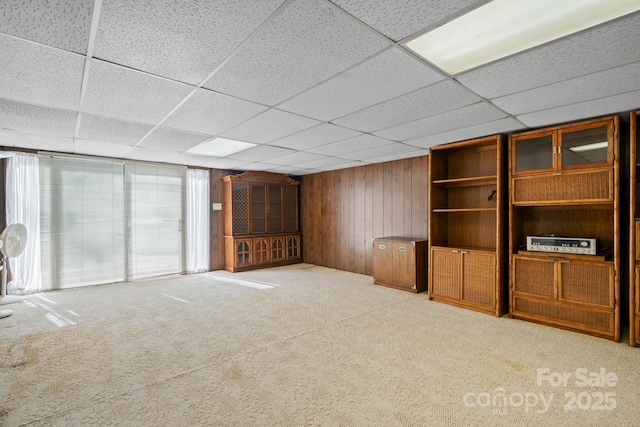 2866 Old Morganton Rd, Lenoir, NC 28645 - unfurnished living room featuring a drop ceiling, wood walls, and carpet floors