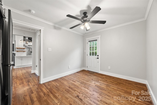 605 Cobb St, Lowell, NC 28098 - spare room featuring wood finished floors, attic access, ceiling fan, ornamental molding, and baseboards