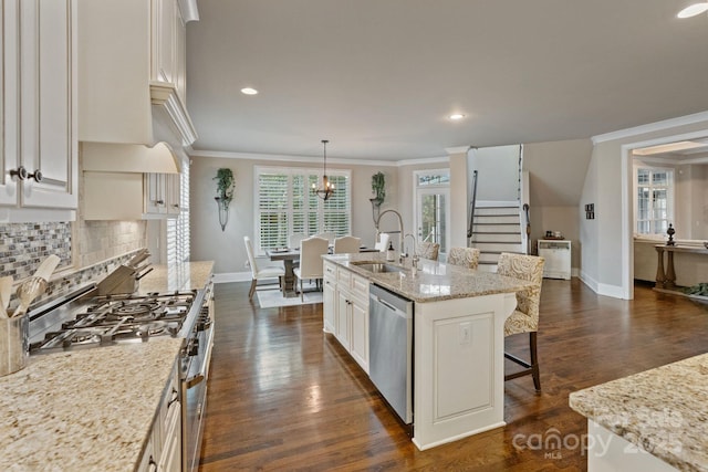 118 Tuscany Trl, Mooresville, NC 28117 - kitchen with stainless steel appliances, a sink, a kitchen bar, baseboards, and ornamental molding