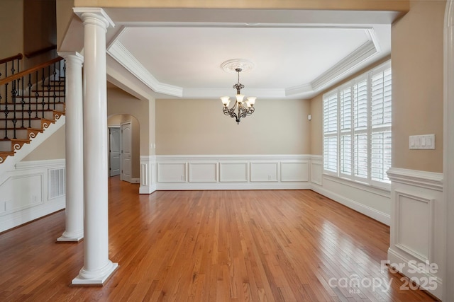 100 Woodwinds Dr, Mount Holly, NC 28120 - unfurnished dining area with a raised ceiling, light wood-type flooring, a chandelier, arched walkways, and crown molding
