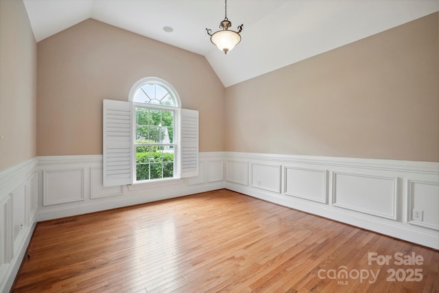 100 Woodwinds Dr, Mount Holly, NC 28120 - unfurnished room featuring a wainscoted wall, vaulted ceiling, and light wood-type flooring