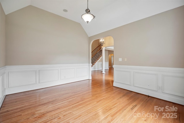 100 Woodwinds Dr, Mount Holly, NC 28120 - unfurnished room with arched walkways, vaulted ceiling, a wainscoted wall, light wood-style floors, and stairs