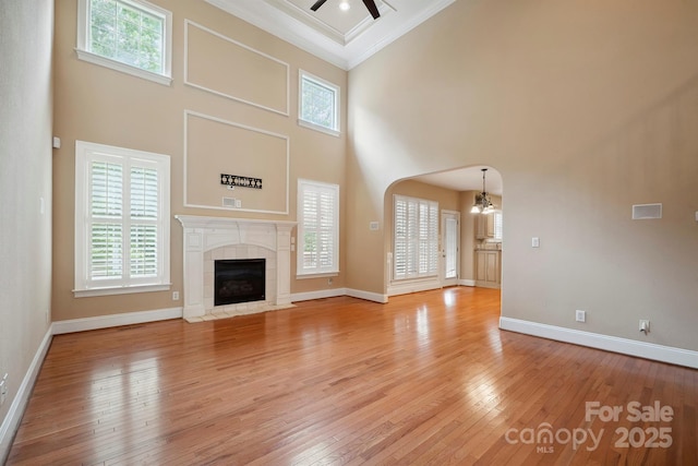 100 Woodwinds Dr, Mount Holly, NC 28120 - unfurnished living room featuring ornamental molding, a chandelier, arched walkways, a high ceiling, and a ceiling fan