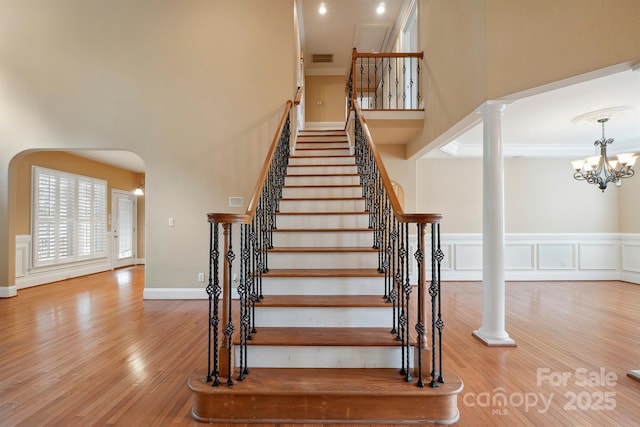 100 Woodwinds Dr, Mount Holly, NC 28120 - staircase featuring a high ceiling, wood finished floors, ornate columns, a chandelier, and arched walkways